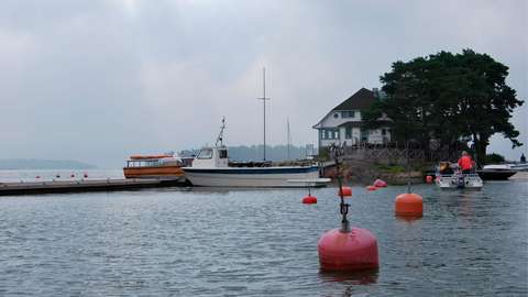 Esbo segelförenings paviljong på Pentala och båtar vid bryggan.