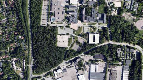 Karamalmsbrinkens område på ett flygfoto. I området finns skog, parkeringsområden och ett parkeringshus.
