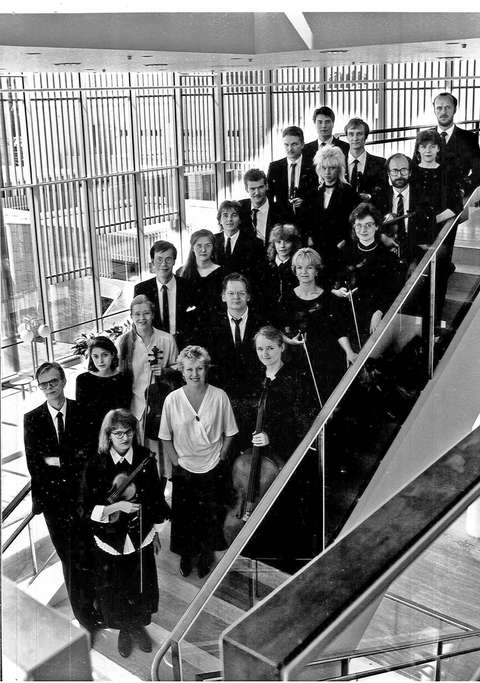 Mustavalkoinen kuva jossa orkesterin jäsenet Espoon kulttuurikeskuksessa.