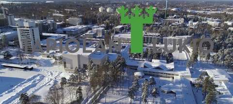 Ilmakuvaa Tapiolasta ja kuvan päällä Tapiolan lukion logo.