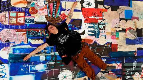 Kim Somervuori makaamassa sinisävyisen teoksen päällä.